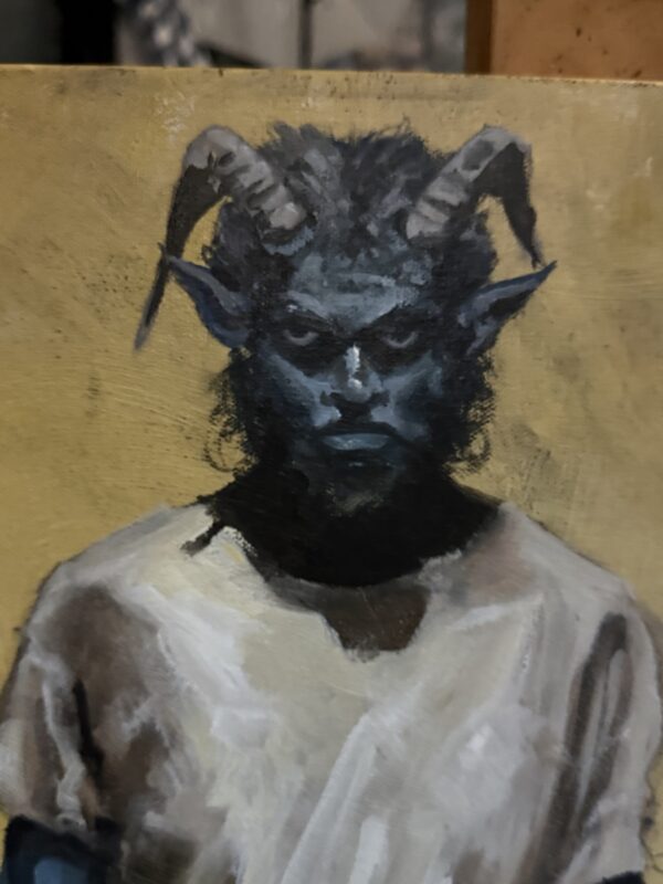 Detail of the blue horned figure’s painted face and white shirt in Defiance